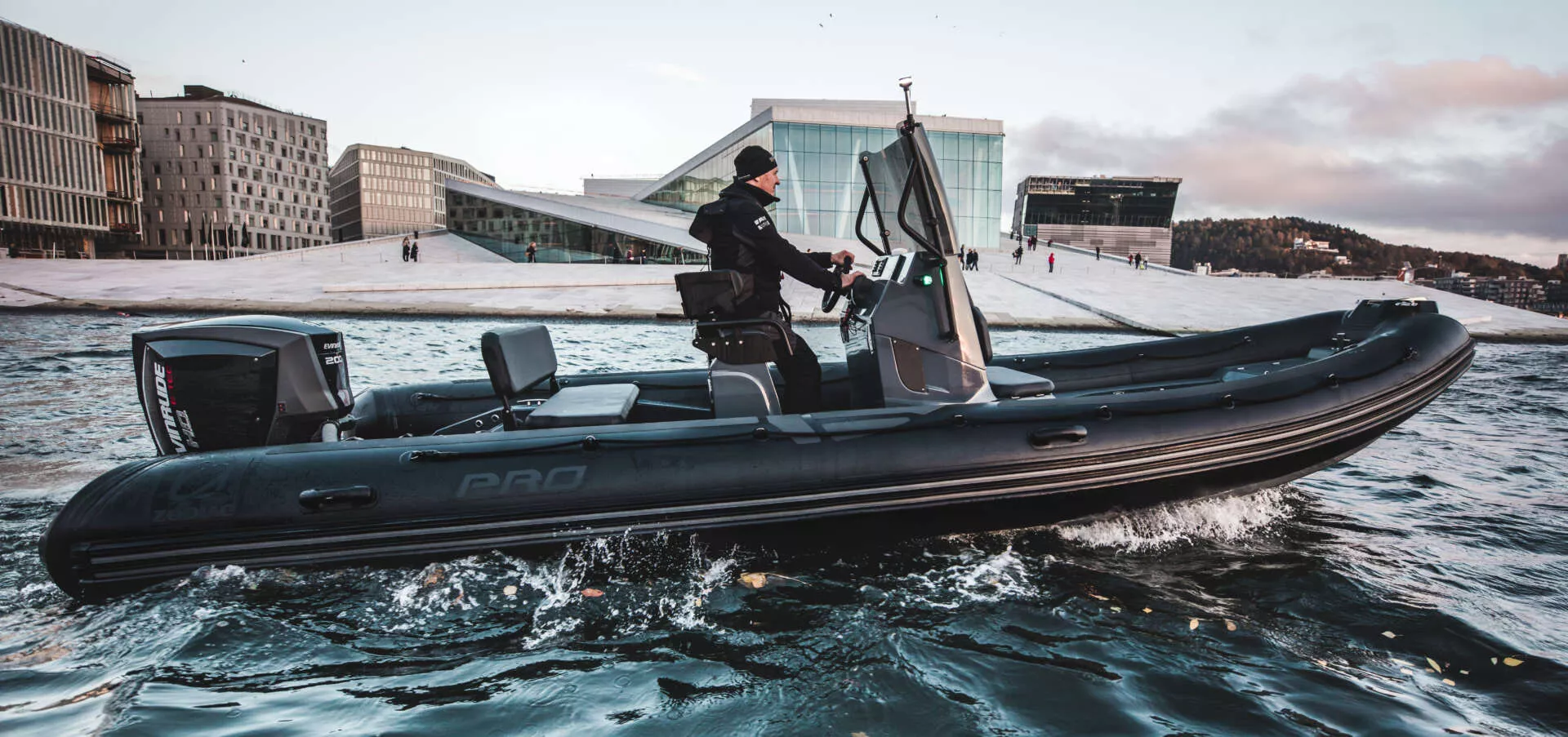 A black Zodiac Pro 7 rigid inflatable boat running across blue water